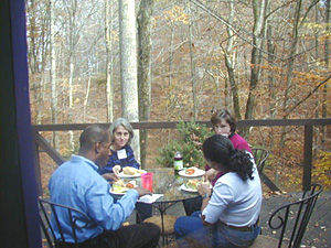 Monet garden setting with  table, chairs and benches, and deck with table and chairs.